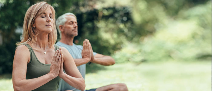a man and a lady outside meditating 